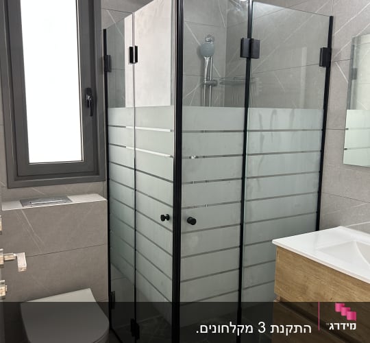 מקלחון זכוכית בחדר אמבטיה מודרני עם כיור ועץ